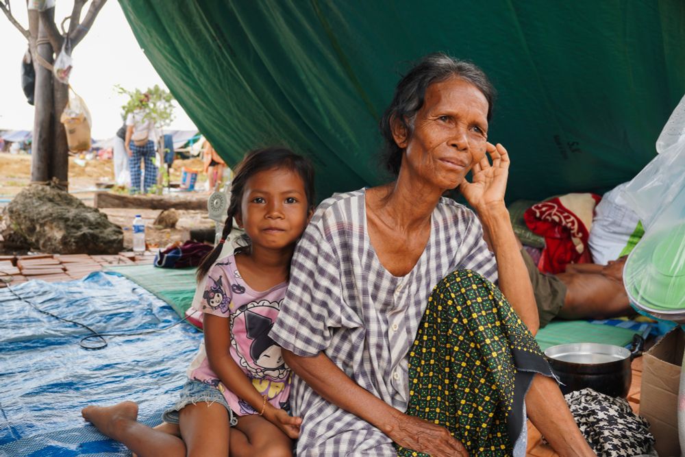 An older woman and a girl in a camp for displaced people in Cambodia