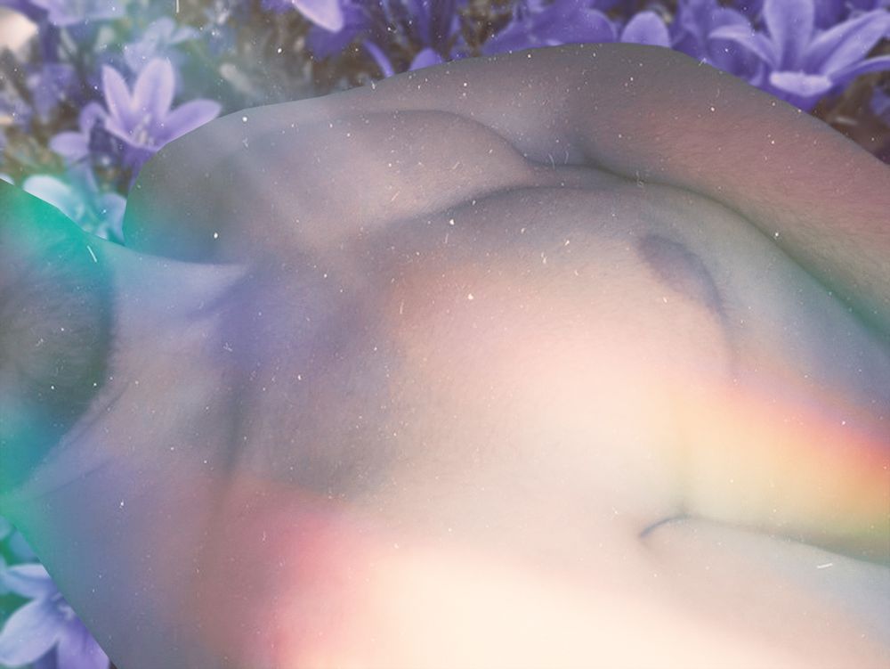 Nude pris en selfie de ma poitrine, pendant que je suis allongée
La photo a des lumières arc-en-ciel et un fond floral avec des fleurs violettes