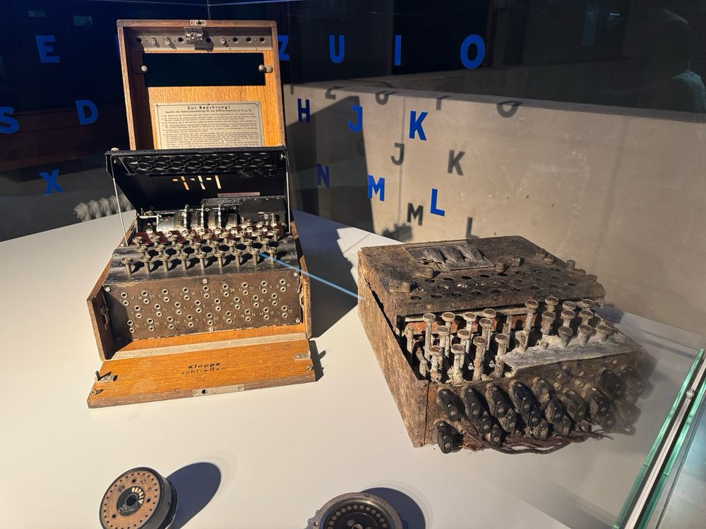 Two Enigma machines in a museum display case