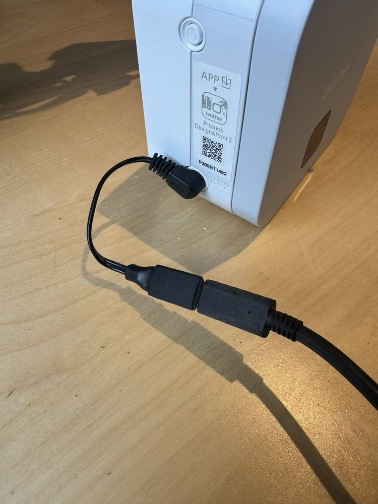 A device being charged via a short dongle that adapts a USB-C cable to a DC barrel connector