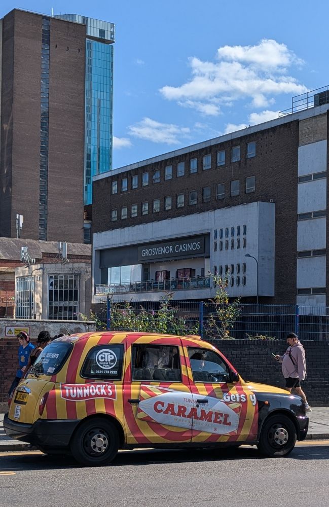 A photograph of a taxi cab in Birmingham which is wrapped in the branding of the Tunnock's caramel wafer bar