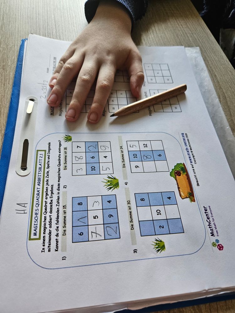 C-Hörnchens Hand und ein Bleistift liegen auf einem Arbeitsblatt mit Matheaufgaben