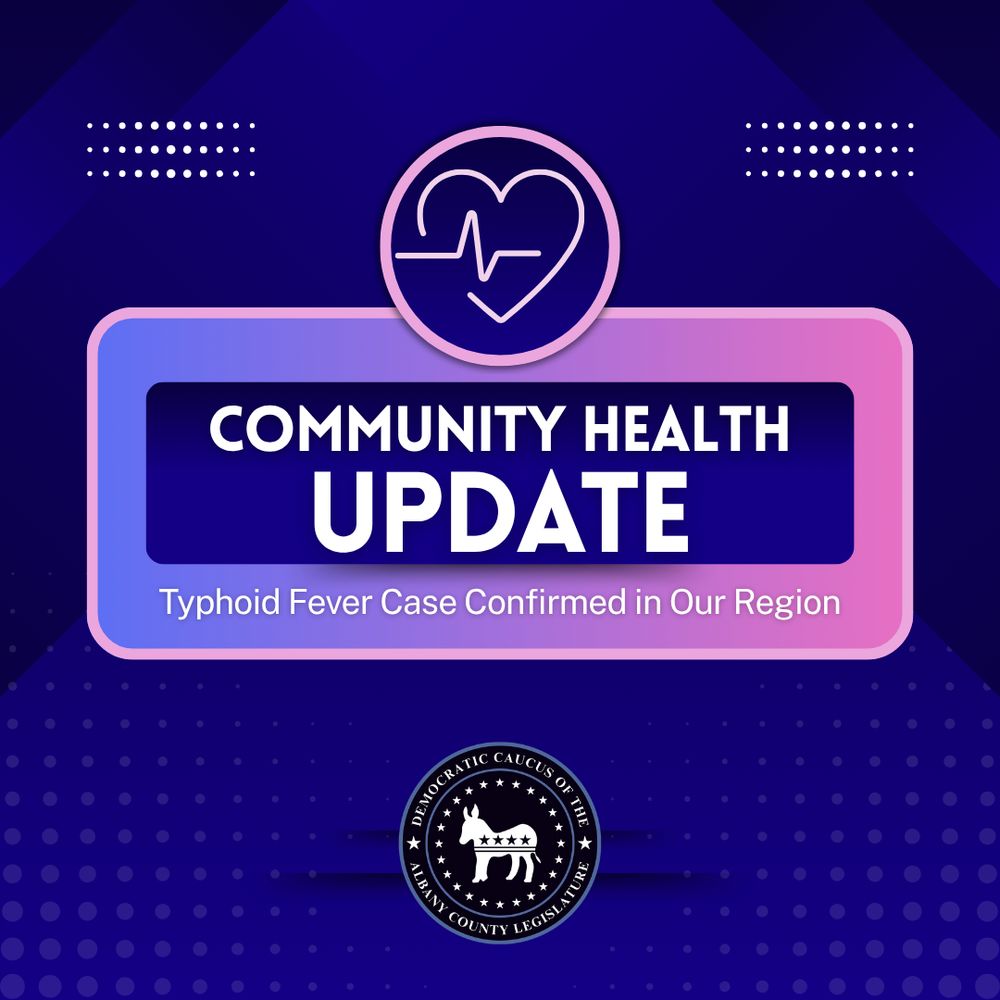 "Graphic with a heart and pulse line icon. Text: COMMUNITY HEALTH UPDATE – Typhoid Fever Case Confirmed in Our Region. Logo of the Democratic Caucus of the Albany County Legislature at the bottom."