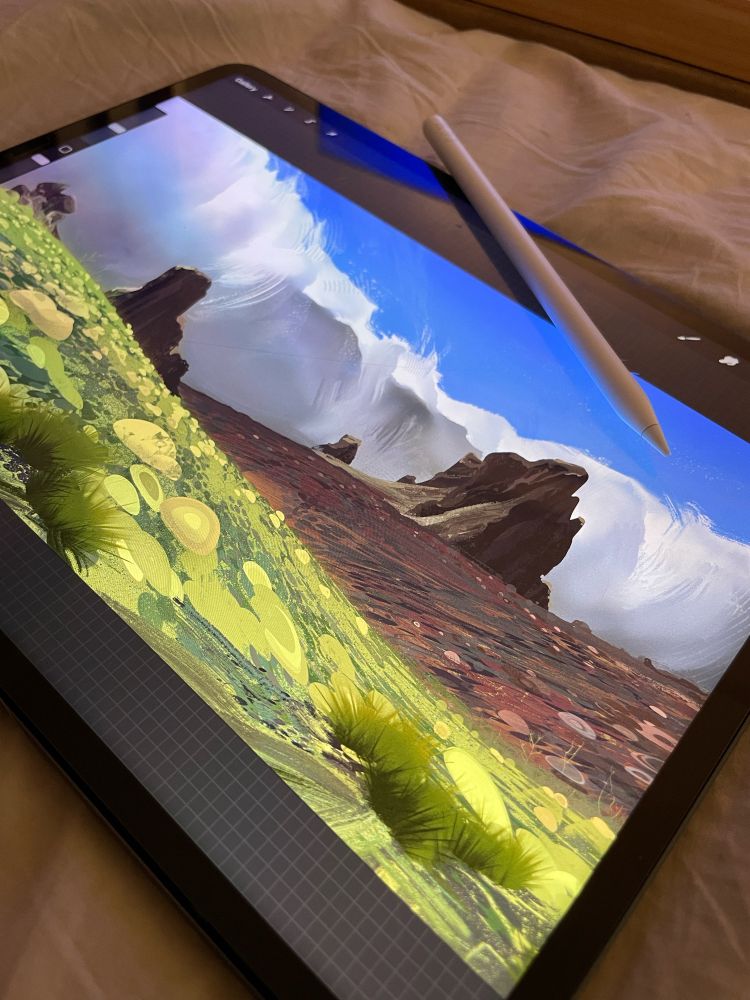 a painting of an arid landscape and big rolling clouds on an ipad