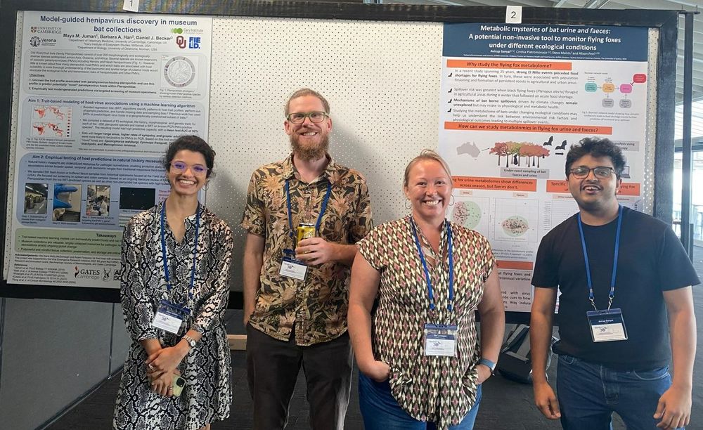 Four researchers stand in front of two scientific posters.