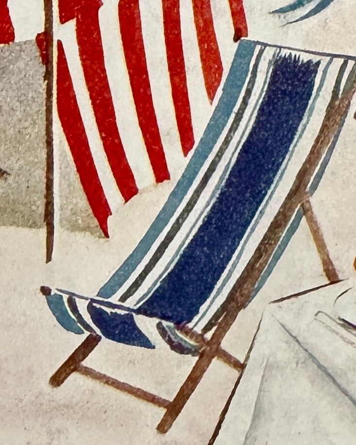 A blue and white deckchair on the beach with a red and white striped tent in the background