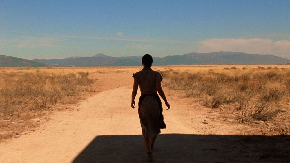 A young woman walks out into the dusty spanish sun to seek help