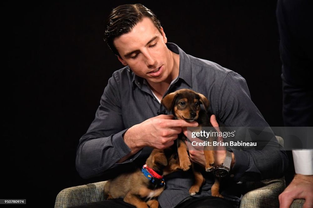 Marc-Andre Fleury holding a puppy and petting it on its chin
