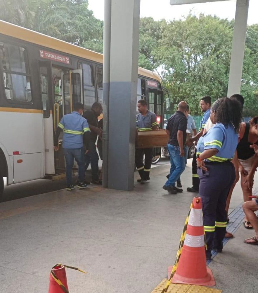 Fiscais de transporte público da Grande Recife colocando um caixão dentro de um ônibus.