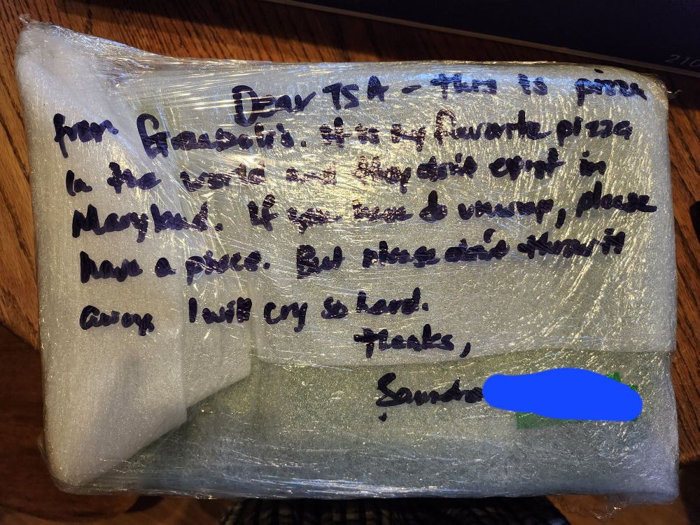 Proof that I packed an entire 18in pizza in my luggage. A plastic wrapped box with a note that says, dear TSA, this is pizza from gramboli's it is my favorite pizza in the whole wide world. They don't have it in Maryland. If you must unwrap please have a piece, but please don't throw it away. I will cry so hard. Thanks, Sanudra