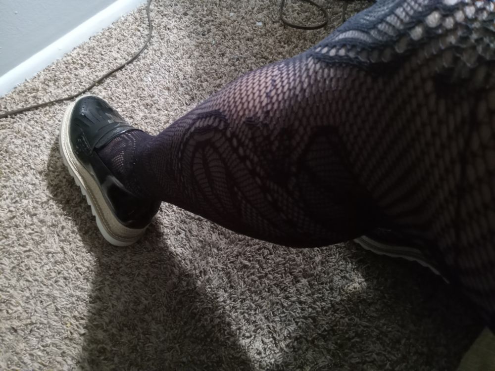  and a shapely leg covered in fishnet lace hosiery on ugly greige shag carpet.