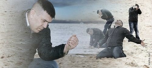 A guy in existential despair on the beach contemplating the sands slipping through his fingers
