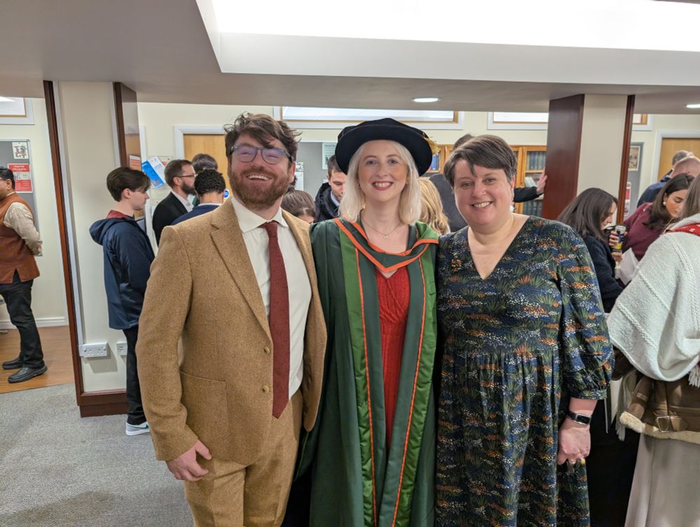 Me, Rosie, and Sara smiling after graduation, with Rosie in her doctor's gown and bonnet. Hurrah! 