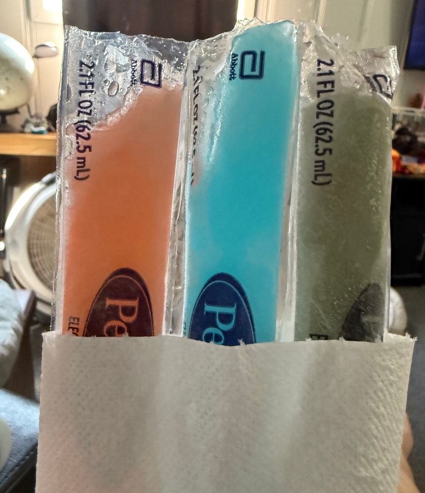 Three pedialyte pops still connected wrapped in a paper towel. 