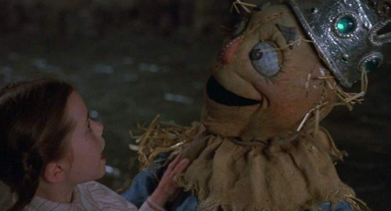 Dorothy and the scarecrow from Return to Oz looking at one another in bewilderment. 