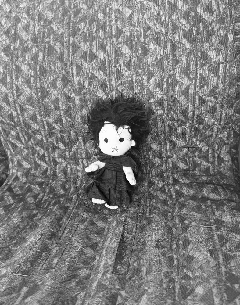 Black and white pic of dream stuffie on a monorail seat