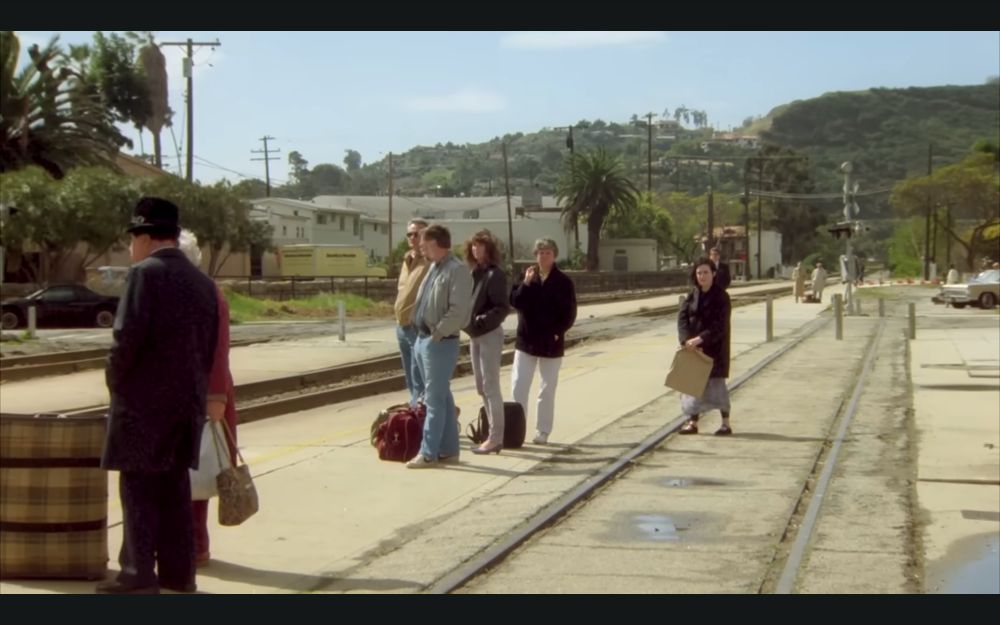 People waiting on platform of Santa Barbara station, notice embedded track and the Mesa in the background, circa 1980s.