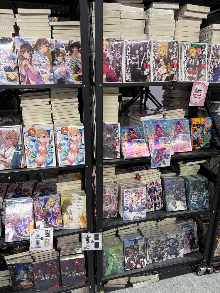 Book shelf full of manga and light novels from various series like “My Plain-looking Fiancé is secretly sweet with me”, “Hey, Wanna Go Out with Me? My Childhood Friend, a Beautiful Girl, Asked for My Help, and Now I've Become Her Camouflage Boyfriend”, “My Wife from the Neighboring Country Is So Cute, I Don't Know What to Do!”, “Trapped in a Dating Sim: The World of Otome Games Is Tough for Mobs”, “Sakamoto Days”, “Oshi no Ko”, and more.