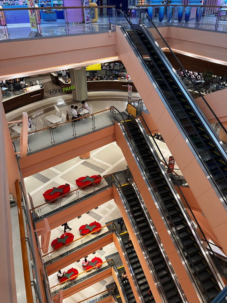 Banks of escalators in atrium from sixth floor of mall. Food court on fifth floor.