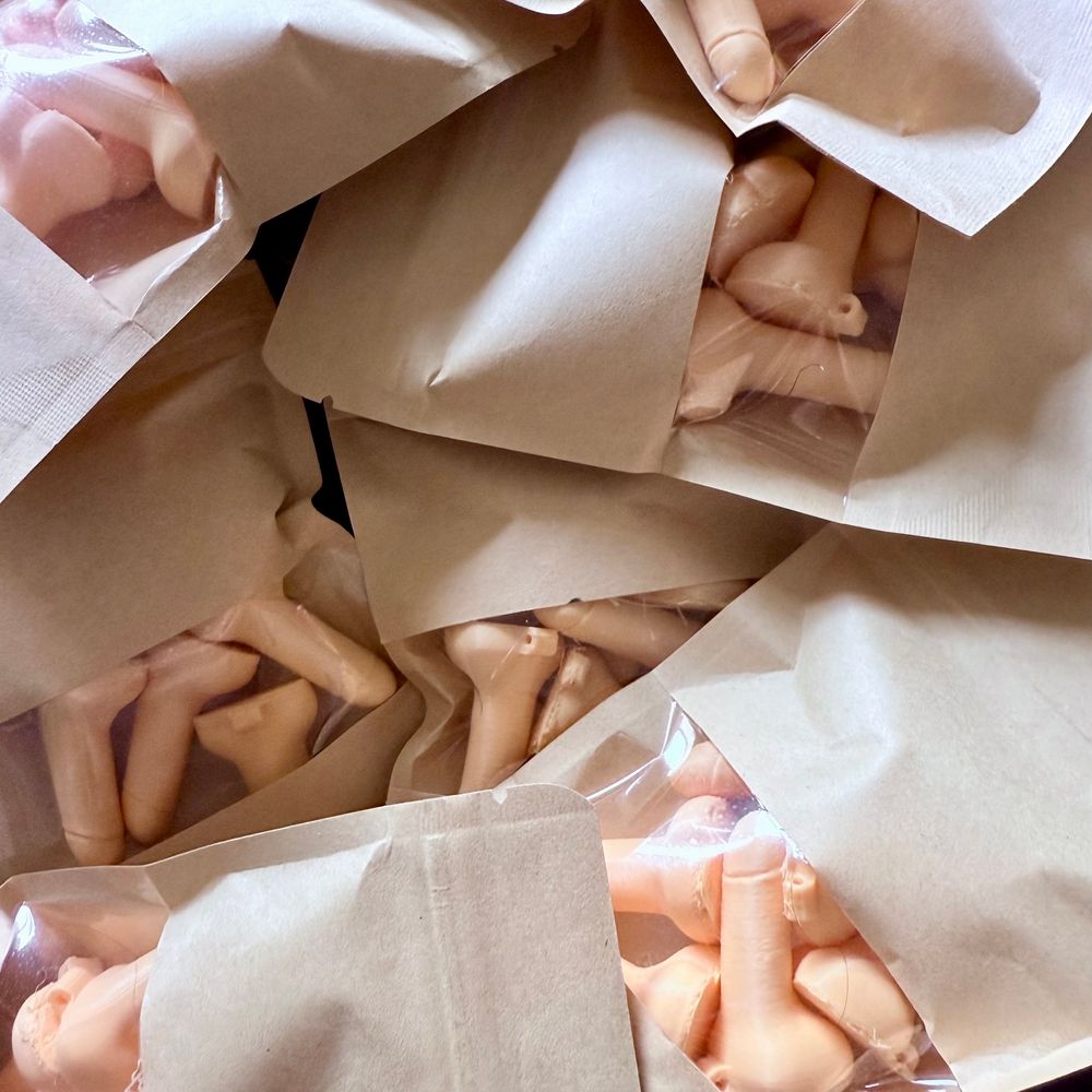 Photo shows many small bags of micro-penises in a light flesh tone. 