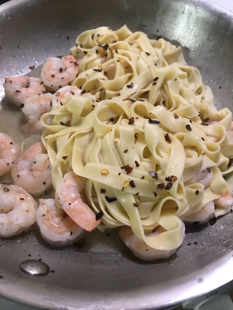 pasta with shrimp and pepper in a stainless steel sauté pan 