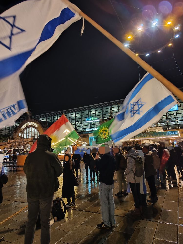 Kundgebung gegen Islamismus und Antisemitismus mit Flaggen Kurdistans und Israels.