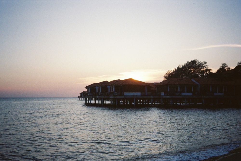 Sunset over the Avillion resort in Malaysia by the sea cottages.