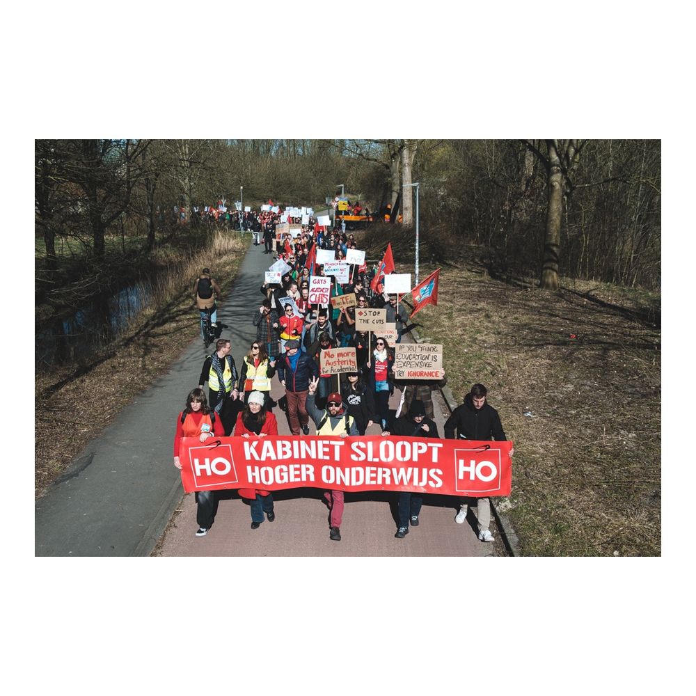 March from the Zernike campus to Groningen city center, part of the university strike against the proposed budget cuts to higher education.
The photo depicts the front line of the march, with people holding a red banner saying “Kabinet sloopt hoger onderwijs”, that means “Cabinet demolishes higher education”