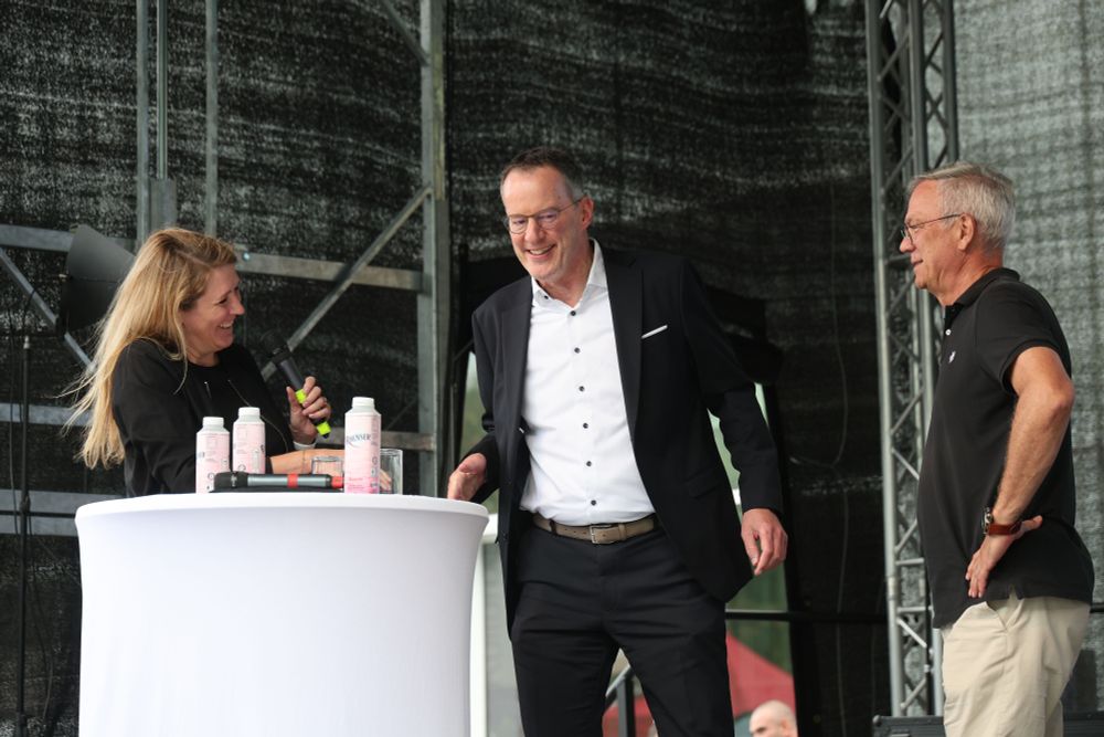 Mara mit Michael Ebling und Rudolf Storck an einem Stehtisch auf einer Bühne, alle drei lachen.
