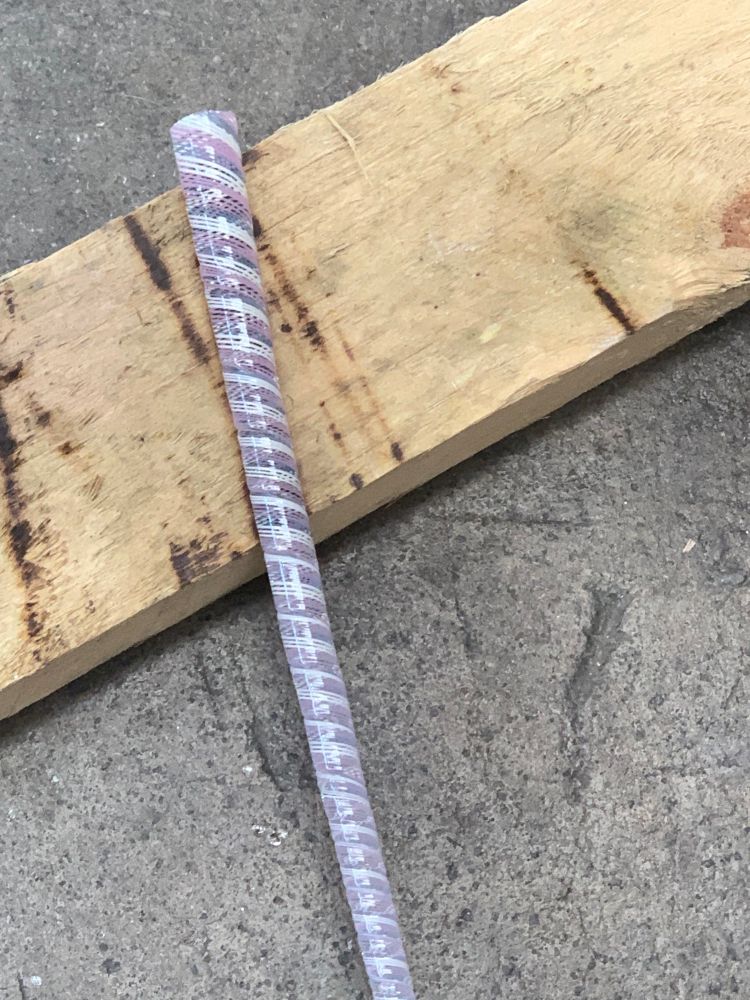 A close up of a twisted pink, white and blue cane