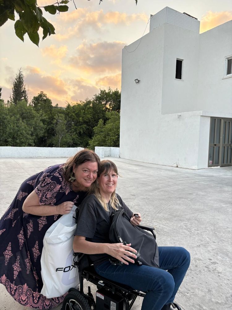 Two people with a background of sunset and a bit of a building