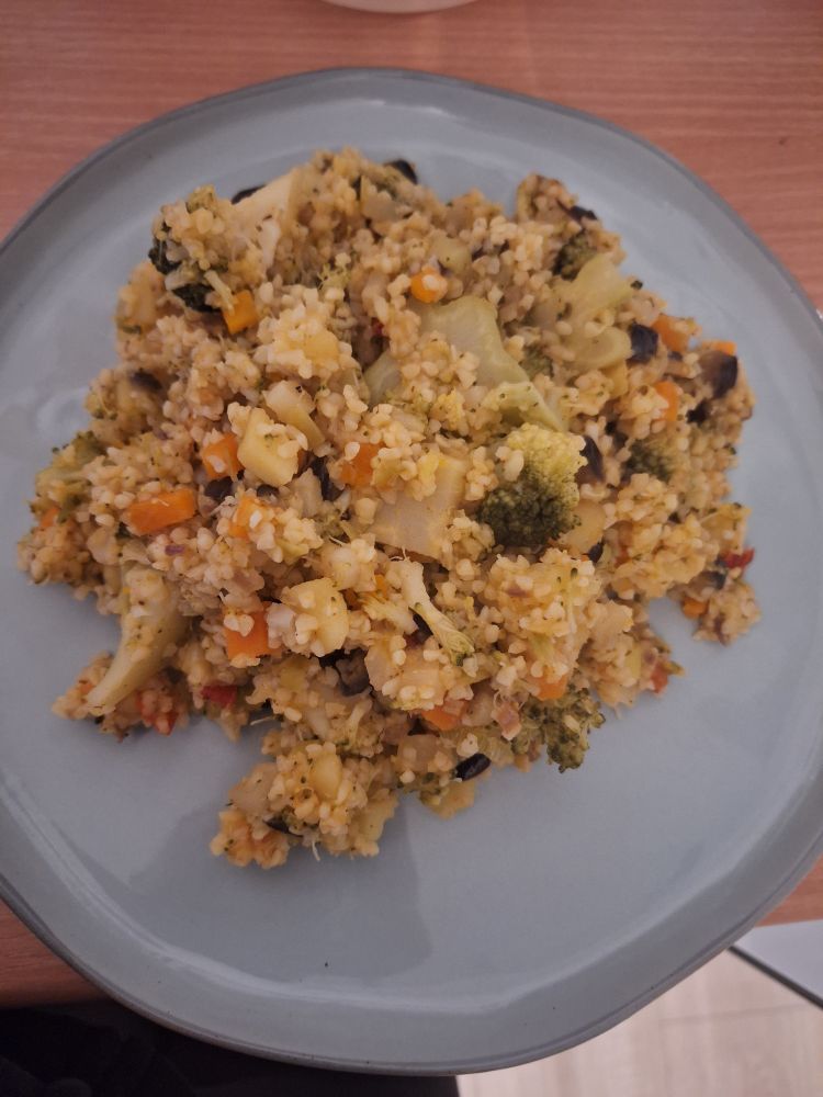 Fertiges Gericht, welches im Post beschrieben wird auf einem blauen Steinteller. Ich nenne es "Coucousgemüse" und nehme es gern zur Resteverwertung. Diesmal waren drin: Couscous, Karotte, Sellerie, Petersilienwurzel, Kartoffeln, rote Paprika, Brokkoli, Aubergine, Lauch, Frühlingszwiebel. Am Ende wird es einfach nur alles zusammen gerührt.