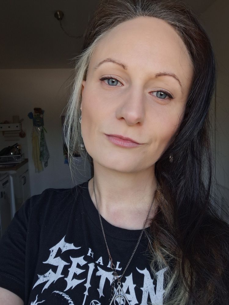 Ein Bild von mir. Irgendwie in heutiger Zeit blöd mich zu beschreiben, aber leider die Wahrheit. Ich bin weiß, blaue-grün-graue Augen, eigentlich blond, aber größtenteils schwarz gefärbt, ein kleiner Teil blond. Mein Undercut ist hier nicht zu sehen. Ich trage mein "Hail Saitan" Shirt und die Kette der "Heiligtümer des Todes". 