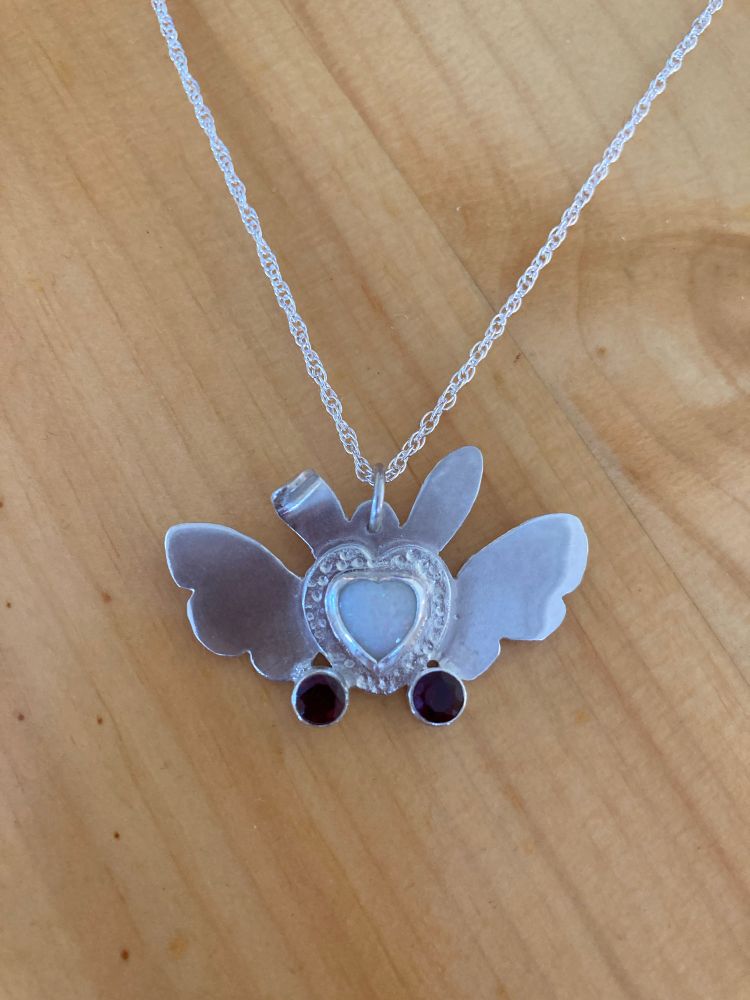 Sterling silver pendant. Bunny eared and angel wings around a heart shaped set opal and two tube set pink garnets.