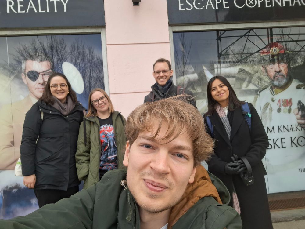 Photo of five very happy group members after a successful escape from an escape room.