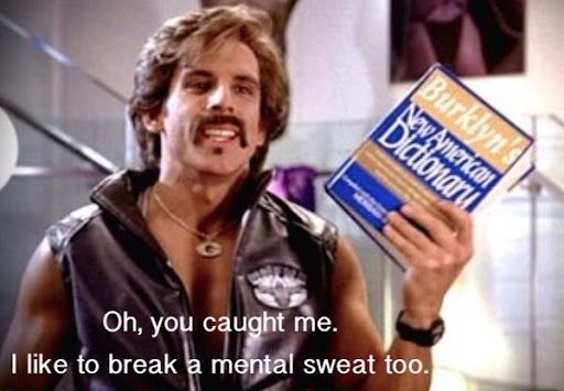 Man with mustache holding up a copy of the New American Dictionary. Caption: Oh, you caught me. I like to break a mental sweat too. 