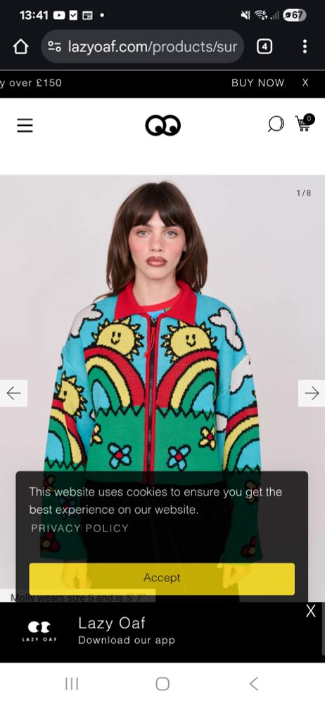 A woman with the thousand yard stare of a traumatised vientnam vet mofels a bright cardigan decorated with rainbows and cartoon suns