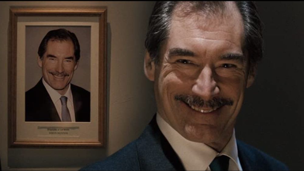 Peirs brosnan in front of a photo of peirs brosnan. Scene from hot fuzz