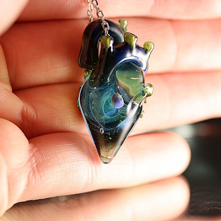 Cœur anatomique en verre et de couleurs bleu qui procède en son centre une galaxie bleu avec une planète ronde qui est une Opal Gilson.
 Créations réalisée artisanalement par Sillycat Glassblower
Anatomical heart in glass and blue colors which has in its center a blue galaxy with a round planet which is an Opal Gilson.
  Creations handcrafted by Sillycat Glassblower