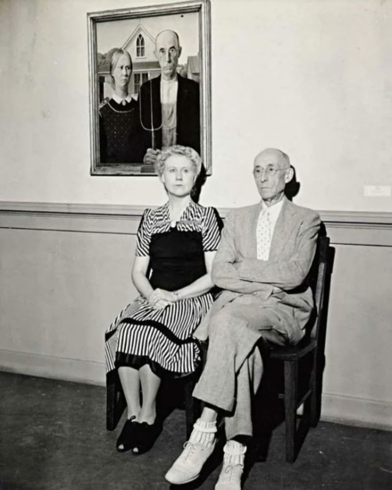 The models for Grant Wood's 𝘈𝘮𝘦𝘳𝘪𝘤𝘢𝘯 𝘎𝘰𝘵𝘩𝘪𝘤 (1930) in front of the iconic painting, 1942. 