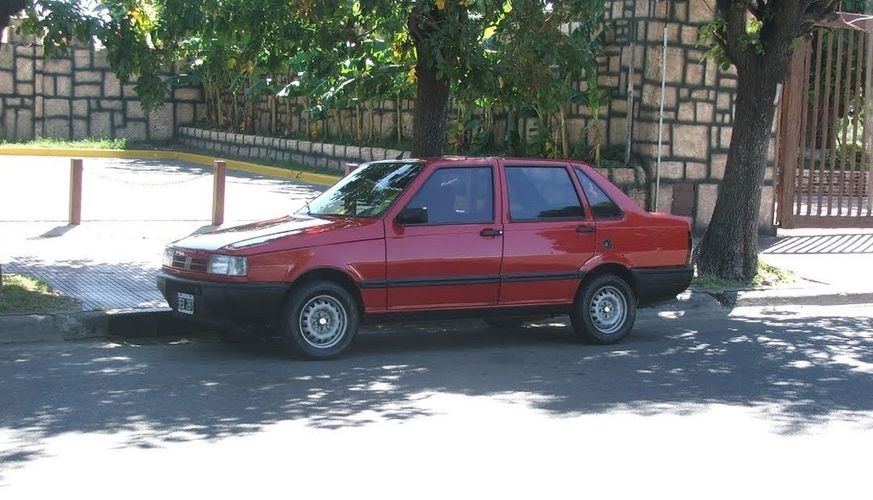 Photo of a red Fiat Duna street parked in Buenos Aires, Argentina. 3/4 front view. Photo by @creatinglightly.art