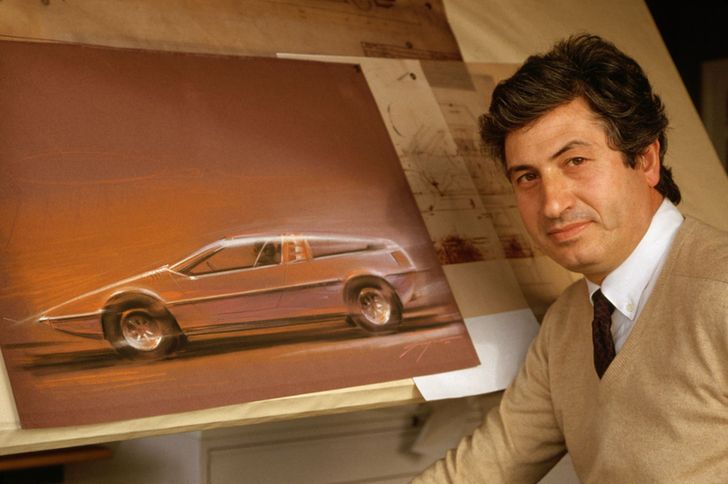 Young Giorgetto Giugiaro next to a drawing board.