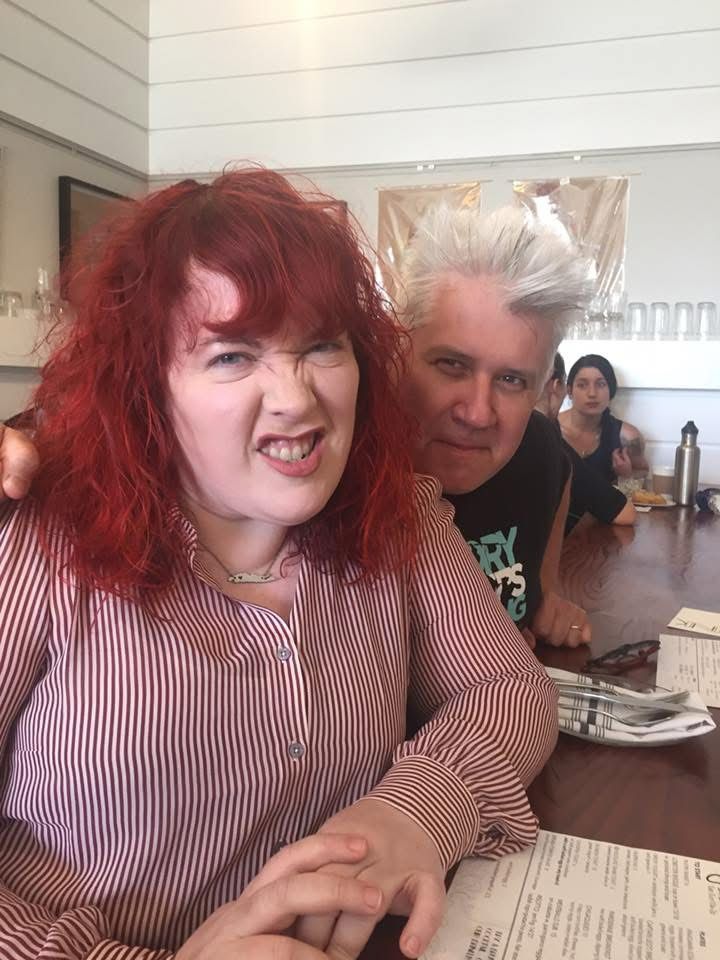 Two extremely attractive people at brunch, a woman with red hair and a man with white hair