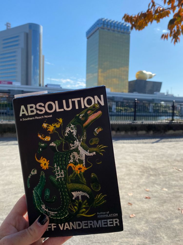 Absolution by Jeff VanderMeer held up in front of the Asahi Head Office in Tokyo, Japan.