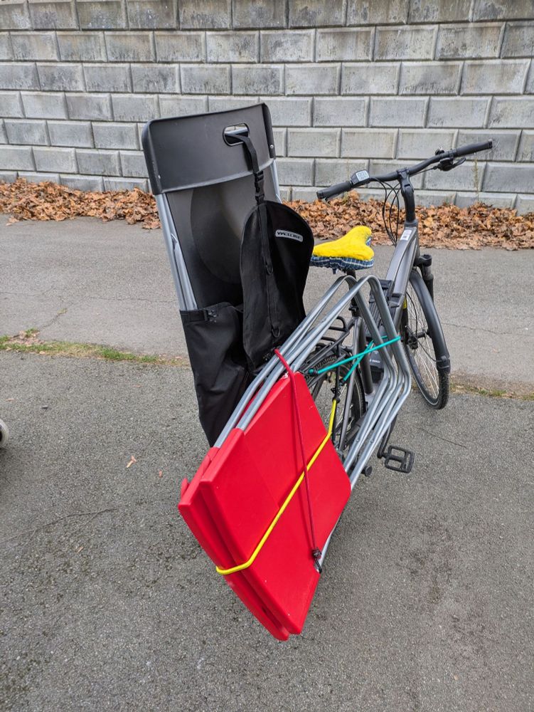 Sykkel med tre klappstoler festet til bagasjebrett og sykkelveske