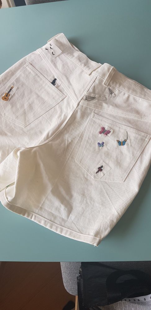 Hvit shorts med broderinger på.