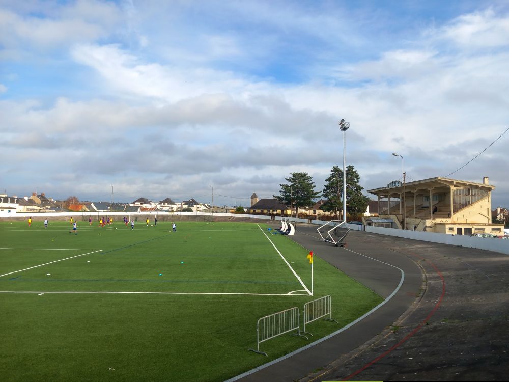 Le stade pendant l'échauffement. A droite la tribune, séparée du terrain synthétique par une vielle piste de vélodrome.