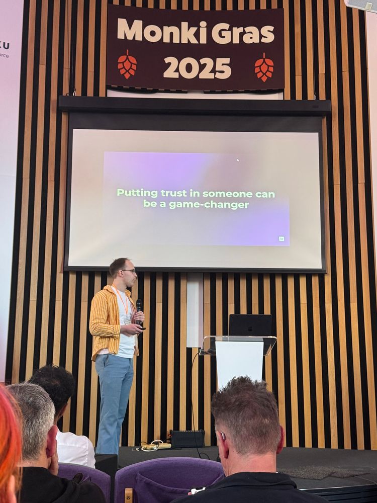 Lucas Käldström talking at Monki Gras 2025 - “putting trust in someone can be a game-changer” can be read in a screen for his presentation 