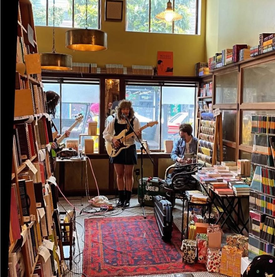 artist playing guitar in the front of the store 