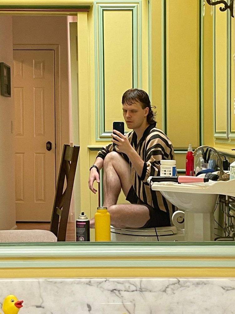 kart sits in a bathroom painted yellow with green accents, a small rubber ducky head peeks out in the bottom left hand corner of the frame